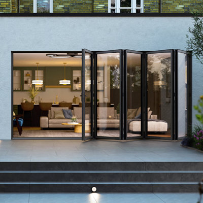 Large, room length modern sliding patio doors with five sections in dark grey opening into a lounge from a patio.