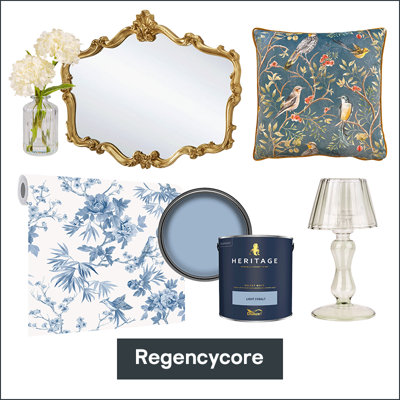A decorative collection featuring a gold ornate mirror, floral cushion, white flowers in a vase, blue floral wallpaper, blue paint, and a glass lamp labeled "Regencycore."