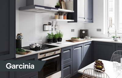 The Garcinia kitchen, featuring dark blue cabinets with integrated handles, and white countertops with grey speckles.