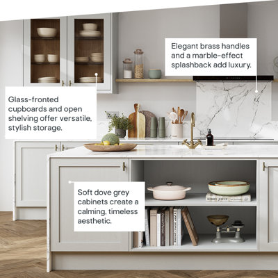 Light grey cabinets create a calming, timeless look. Glass-fronted cupboards and open shelving offer versatile stylish storage. Elegant brass handles and a marble-effect splashback add luxury.