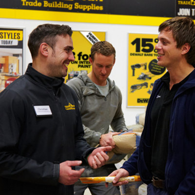 Tradespeople in a TradePoint store smiling and discussing TradePoint membership benefits