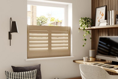 Modern home office with pale wooden cafe shutters on a casement window.