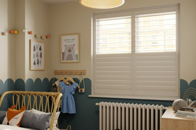 White shutters half open installed in a child's bedroom.