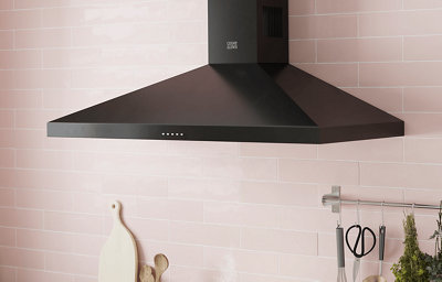 A contemporary black, matt finish cooker hood is contrasted against light pink tiles on the kitchen wall.