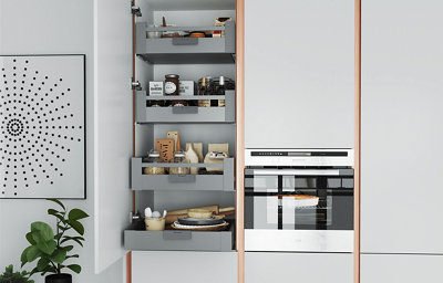 A gloss light grey kitchen showing a larder cabinet open to reveal the contents inside.