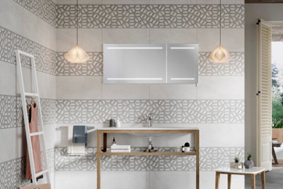 A large bathroom with alternating white and grey bathroom tiles laid in horizontal stripes.