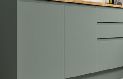 Close up of Garcinia matt slab doors with integrated handles in a soft green tone, paired with medium tone wood worktop for a refined, modern finish.