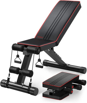 Man working out on adjustable sit up bench in modern gym Stock