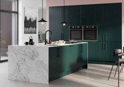 Kitchen featuring classic shaker doors in dark green with a matt finish. A kitchen island is enveloped in a marble-effect worktop all the way to the floor. Built-in appliances and a matt black tap and hanging light pendants complete the look.
