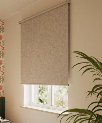 Cream black out blinds next to a houseplant.