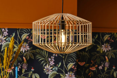 A close up of a bamboo lampshade in a room with botanical print wallpaper.