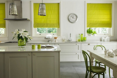 Green roman blinds in a white modern kitchen.