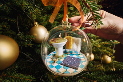 Bauble with a dirty blocked sink, towels and bath mat inside.