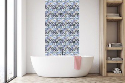 Multicoloured mosaic splashback feature wall in a white bathroom besides a freestanding white bathtub.