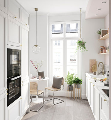 White galley kitchen with large window at the end letting plenty of natural daylight in to the room.