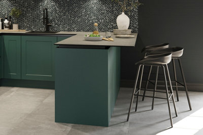 A black and green kitchen with a peninsula breakfast bar and black bar stools.