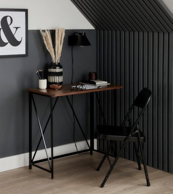 A black and white home office with black wall panelling on the right side of the desk.