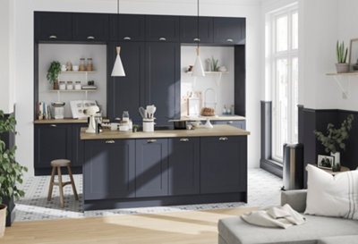 A blue and white shaker kitchen with a large island and wooden worktops.