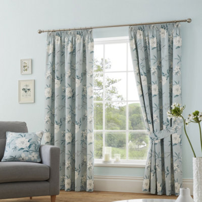Blue floral pencil pleat curtains in a blue living room.