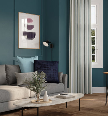 A blue living room with a grey sofa and blue cushions.