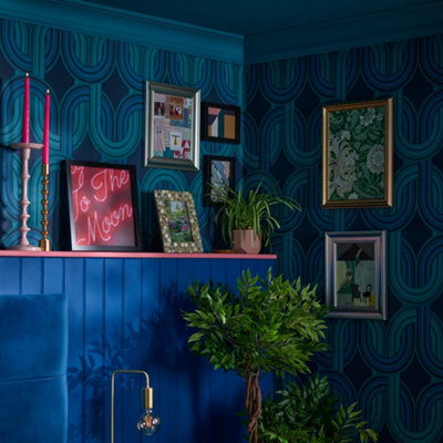 A bold blue living room with a selection of art prints on wall.