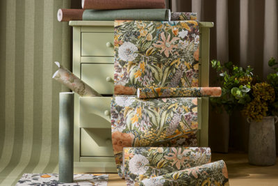 Make every wall a statementcreate a space you love with our new wallpaper.Close-up of new wallpaper range featuring botanical floral patterns in greenochre and pink tones displayed with plain textured rolls on a green chest of drawers.