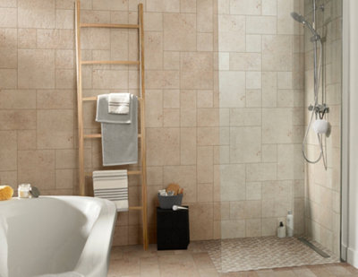 Bathroom with beige wall tiles on all four walls, creating a walk-in shower.