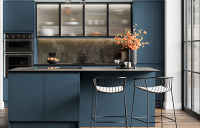 The Garcinia kitchen features matt slab doors with integrated handles in a rich dark tone, paired with ribbed glass wall units and metallic accents for a modern, sophisticated feel.