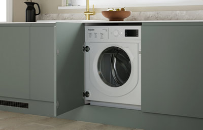The Garcinia kitchen features matt slab doors with integrated handles in a calm green tone, paired with marble-effect worktops for a fresh, modern look.