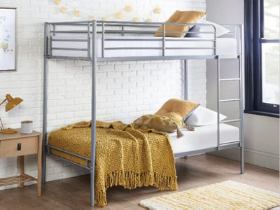 A metal bunk bed with a single bed on top of another, connected by a ladder, in a modern bedroom.
