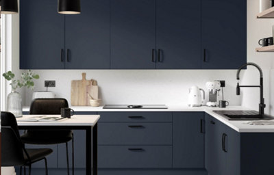 The Ethos kitchen, featuring sleek dark blue cabinets, chrome fixtures and cupboard handles, and light wood-effect countertops.
