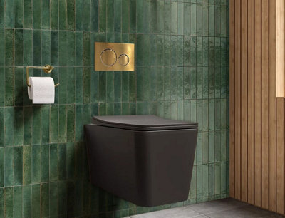 A bathroom with a black toilet and bottle green and tiles.