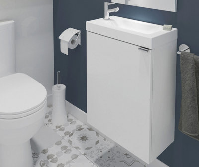 White wall hung vanity unit in small blue and white cloakroom.