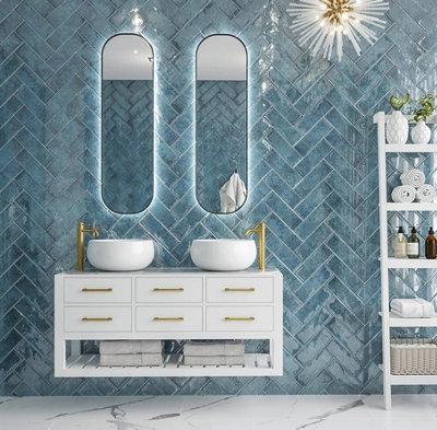 A modern bathroom with blue metro tiles covering the entire wall, laid in a herringbone pattern.