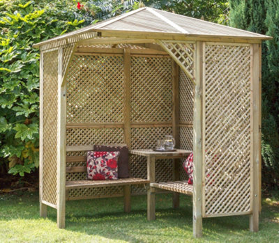 A freestanding corner pergola with built-in benches and a table, creating a shaded outdoor retreat.