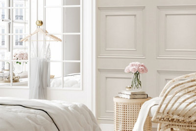 Cream wall panel effect wallpaper in a bedroom.