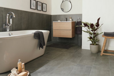 Large bathroom with grey tiles expending from the floor halfway up bathroom wall, the rest of the wall is painted white.