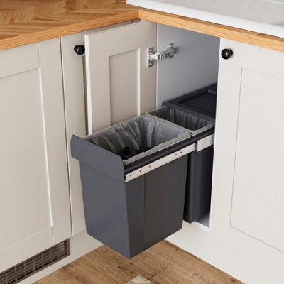 Cream and wooden kitchen with an open cupboard showing an integrated pull-out bin.