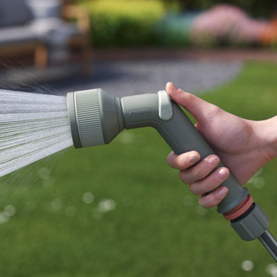 A garden hose spraying water onto a lawn.