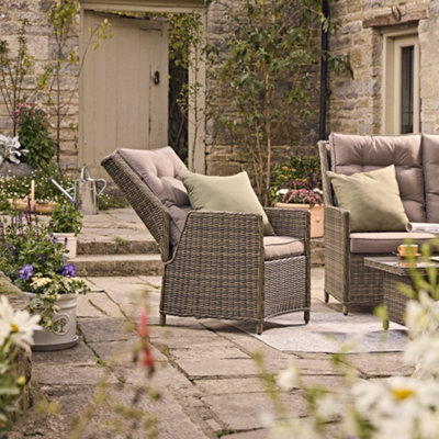 Two reclining garden chairs with removable cushions on a patio.