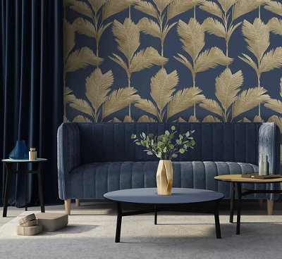 A dark blue living room with gold metallic wallpaper and a blue sofa and round black coffee table.