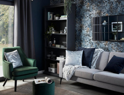A dark blue living room with metallic and velvet soft furnishings.
