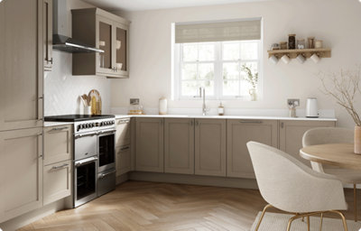 The L-shaped kitchen is bathed in light from a nearby window, showing the matt finish of the cabinets creates a uniform look in any light.