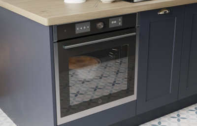 Close up of  Artemisia midnight blue kitchen shaker with integrated oven and light wooden worktop