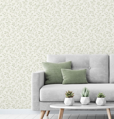 Delicate green leaf wallpaper in a living room with a grey sofa and green cushions.