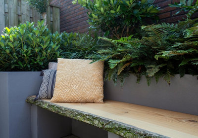 Rustic garden bench made from weathered wood, blending seamlessly into the natural landscape as a charming focal point.