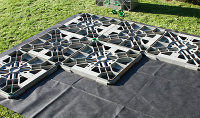 A plastic shed base made up of interlocking plastic squares that form a stable foundation.