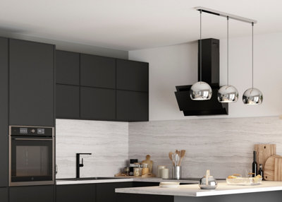 Pendant light with three chrome-effect globe shades hanging above a kitchen island, creating a striking focal point.