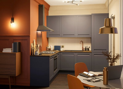 Small open plan kitchen living area with blue kitchen cabinets and a striking orange feature wall.