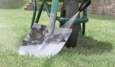 Using a pressure washer to remove mud from a spade.